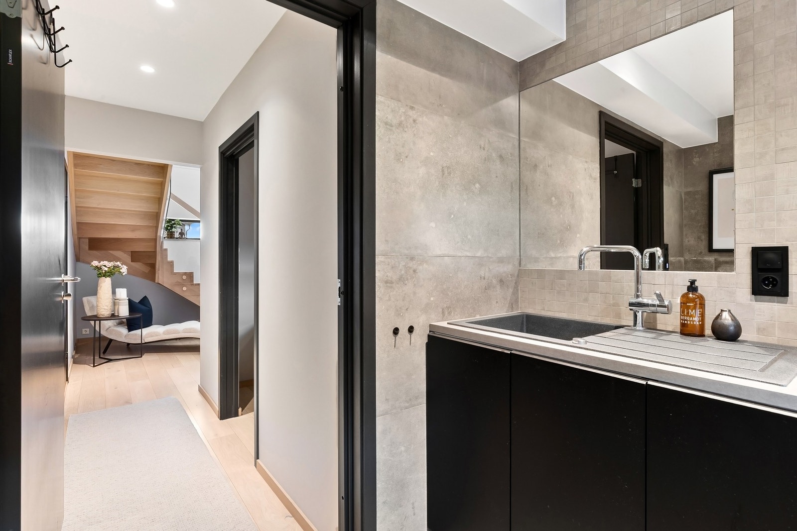 Badet i underetasjen kombinerer vaskeromsfunksjon og baderom på en elegant måte. Galleribilde