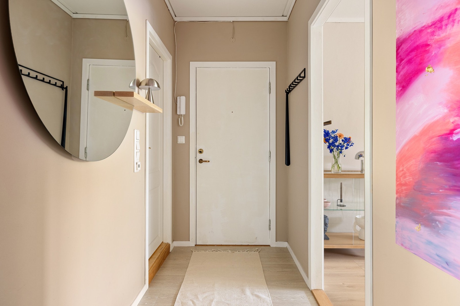 En innbydende entré med 1-stavs laminat på gulv, slette malte vegger og plass til oppbevaring av yttertøy og sko. Galleribilde