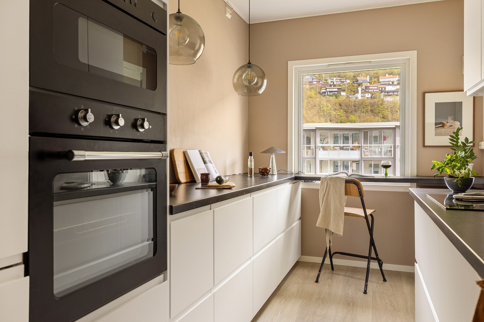 Det har en moderne innredning med slette fronter, laminat benkeplate og nedfelt vask i kompositt. Det er godt med skap- og benkeplass, samt integrerte hvitevarer bestående av stekeovn, micro, oppvaskmaskin, kjøleskap med frysedel, platetopp og ventilator. Galleribilde
