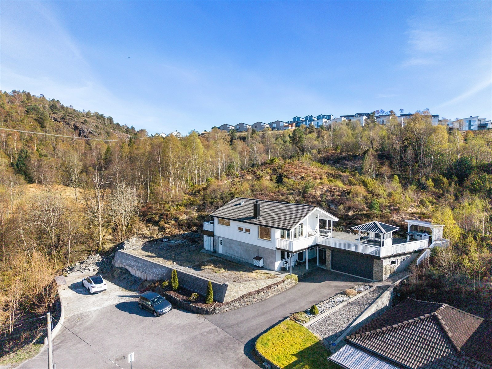 Eiendommen har godt med plass for parkering og en dobbelgarasje fra 2016 med elbillader og automatisk portåpner. Galleribilde