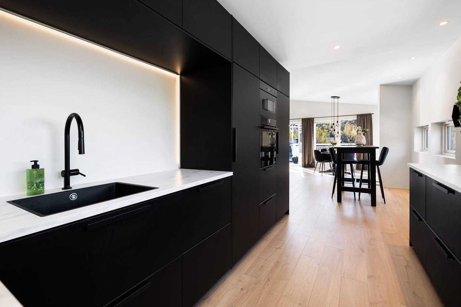 Innredningen har et stilrent design med sorte fronter og lys benkeplate. Galleribilde