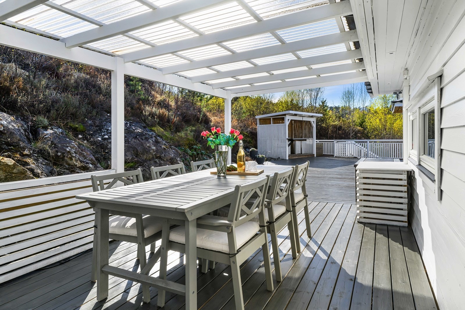 En annen del av altanen er overbygget med transparent tak, perfekt for en spisegruppe. Galleribilde