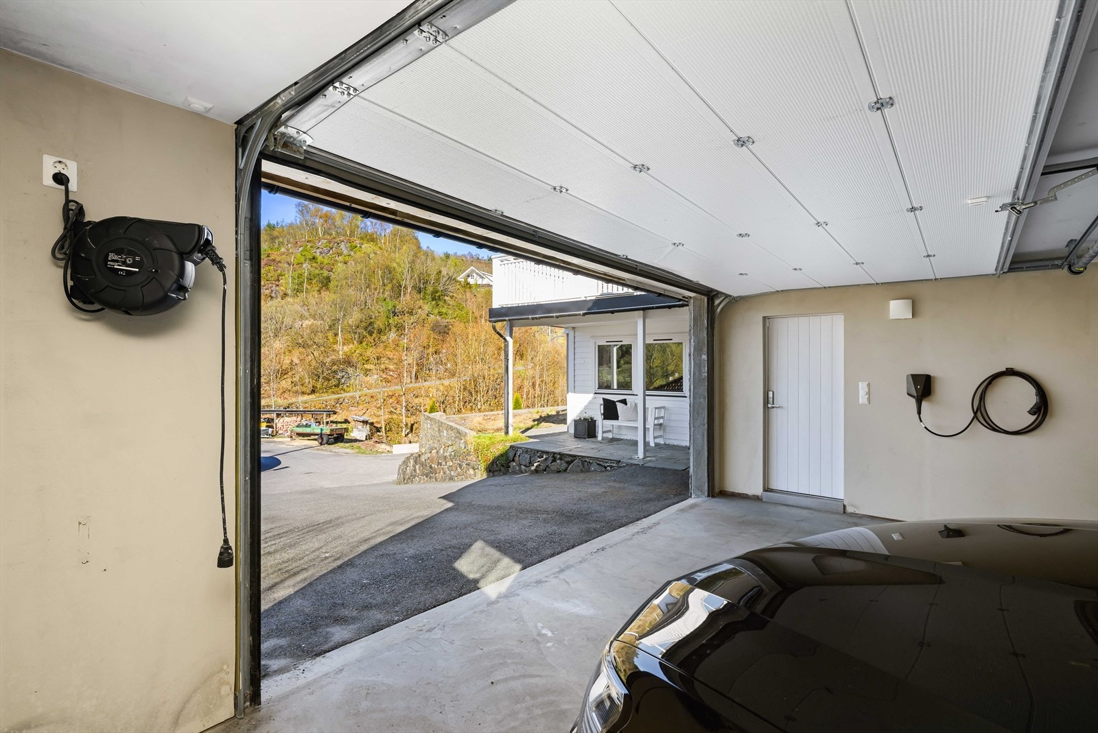 Garasjen har leddport med automatisk åpner og lader for elektrisk bil. Galleribilde