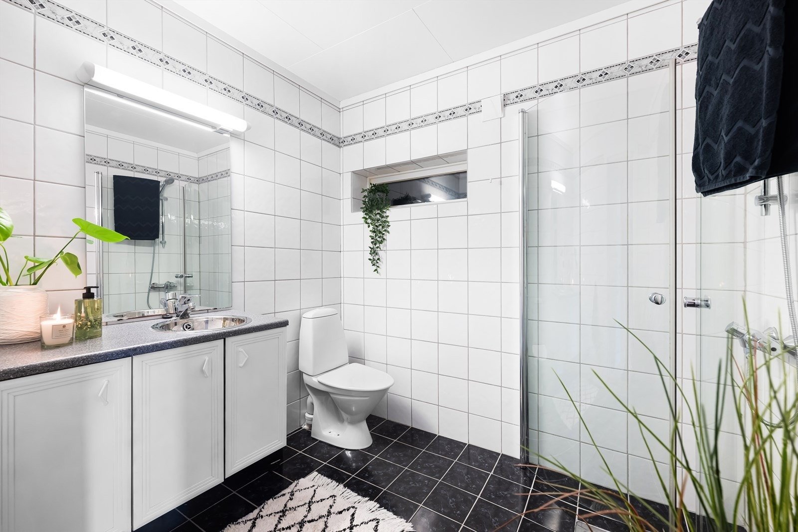Det helflisete badet i første etasje er fra 2003. Det er holdt i lyse farger med mørkt gulv som kontrast. Galleribilde