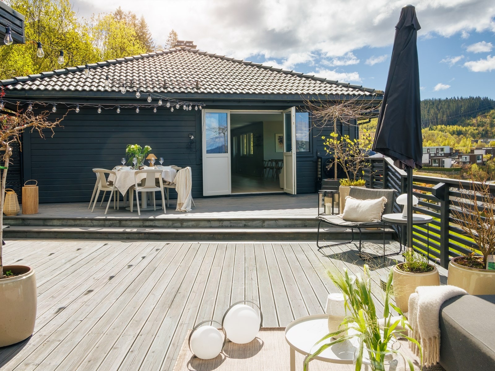 Terrassedørene skaper en sømløs overgang mellom uteplassen og den åpne stue- og kjøkkenløsningen - perfekt for sosiale sammenkomster på fine dager. Galleribilde