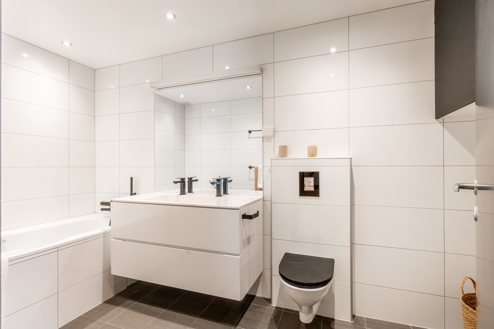 Praktisk løsning med både dusjnisje og badekar. Videre har badet veggmontert wc og servantskap med to ettgreps blandebatterier fra Duxa. Galleribilde