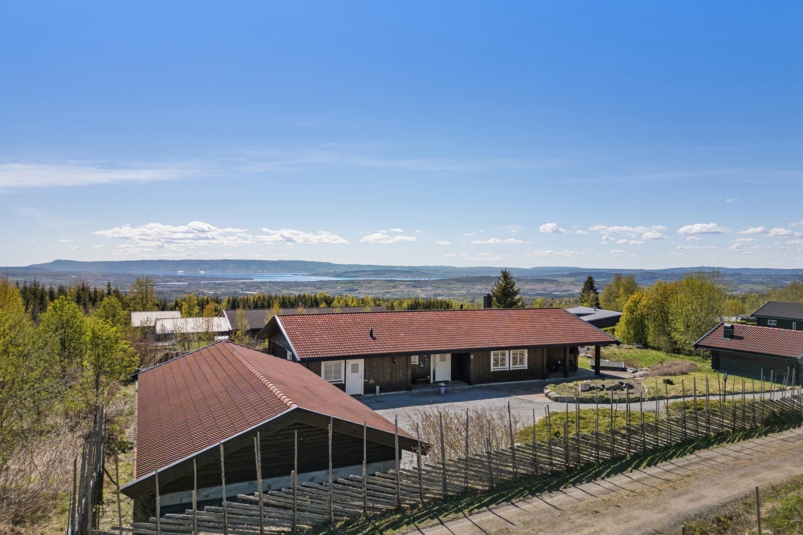 Gruset gårdsplass med god plass til parkering foran boligen og garasjen. Galleribilde