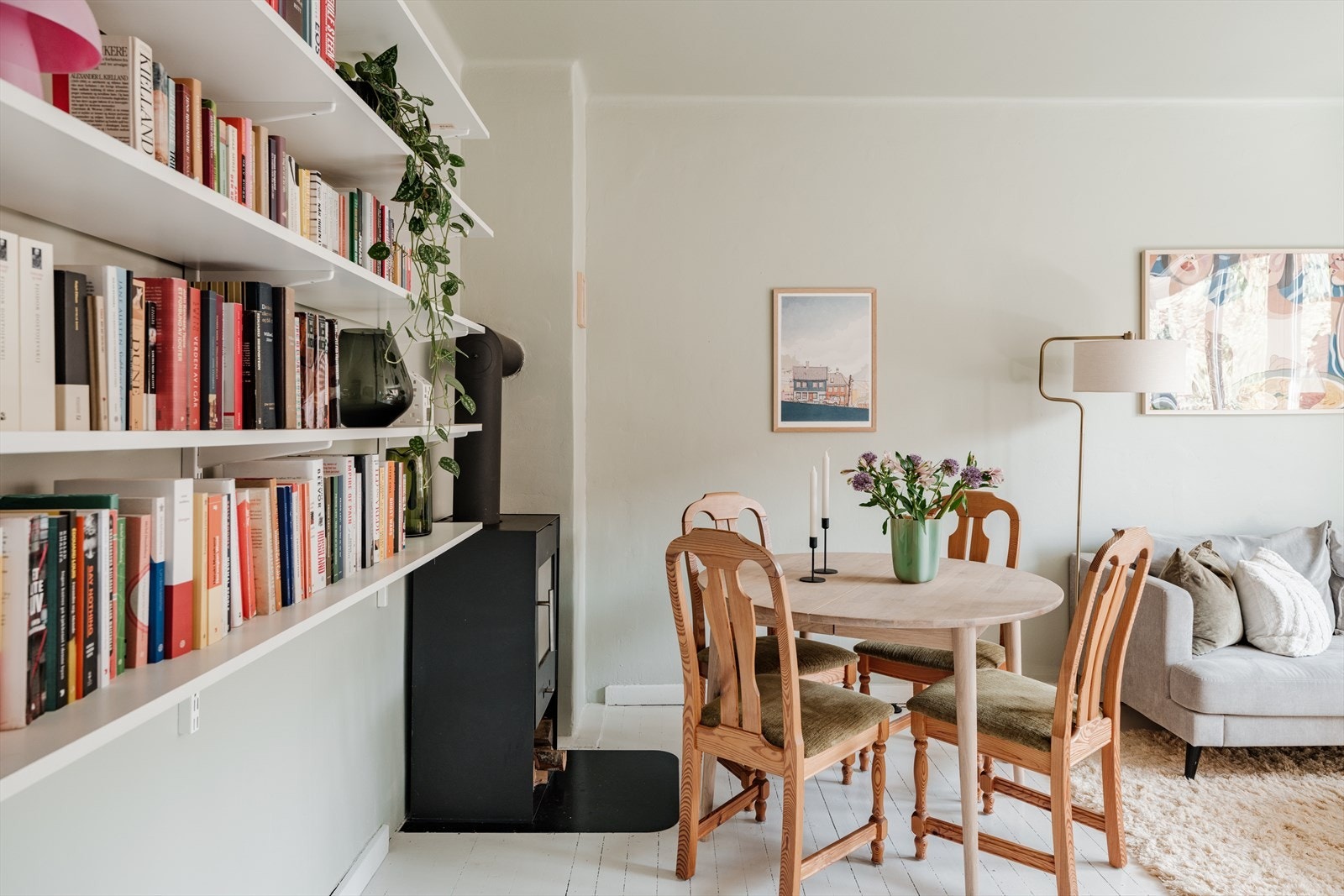 Videre har rommet vegghengt bokhylle og peis. God plass til både spisebord og sofagruppe. Galleribilde