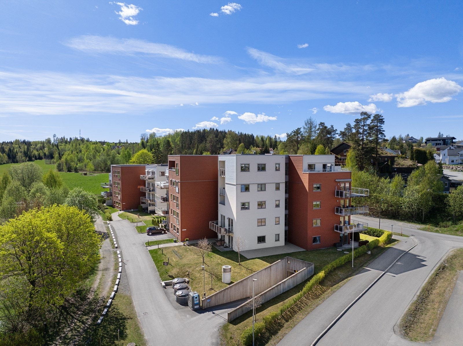 Leiligheten har en pen fasade og nedkjøring til garasjeanlegget. Galleribilde