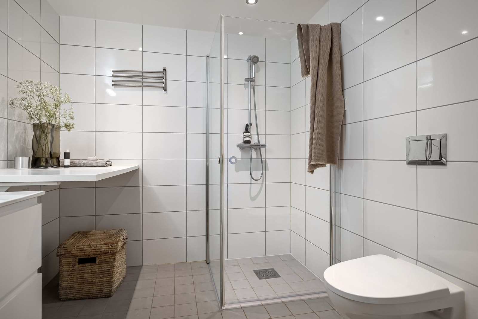 Badet er utstyrt med vegghengt toalett og dusjhjørne med innfellbare glassdører Galleribilde