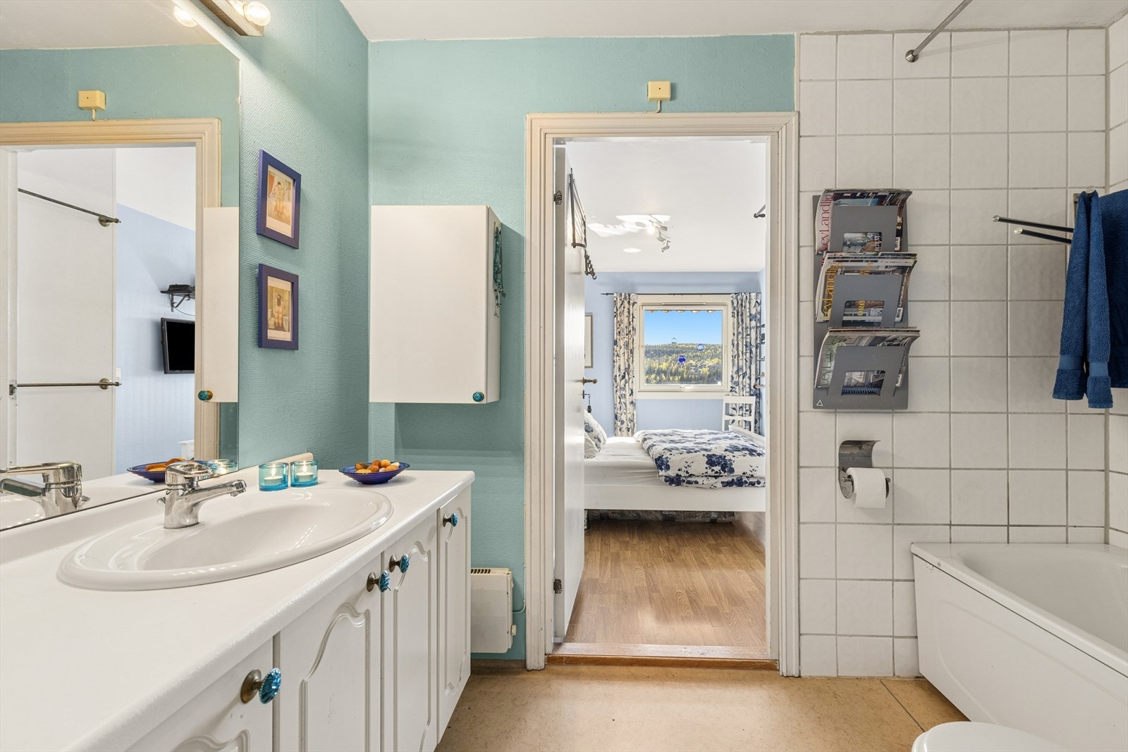 Badet gir boligen en ekstra komfort i hverdagen og er innredet med nedfelt servant, toalett, badekar og opplegg for vaskemaskin. Veggene har fliser og malte plater, gulvet har vinylbelegg, og rommet har mekanisk avtrekk. Galleribilde