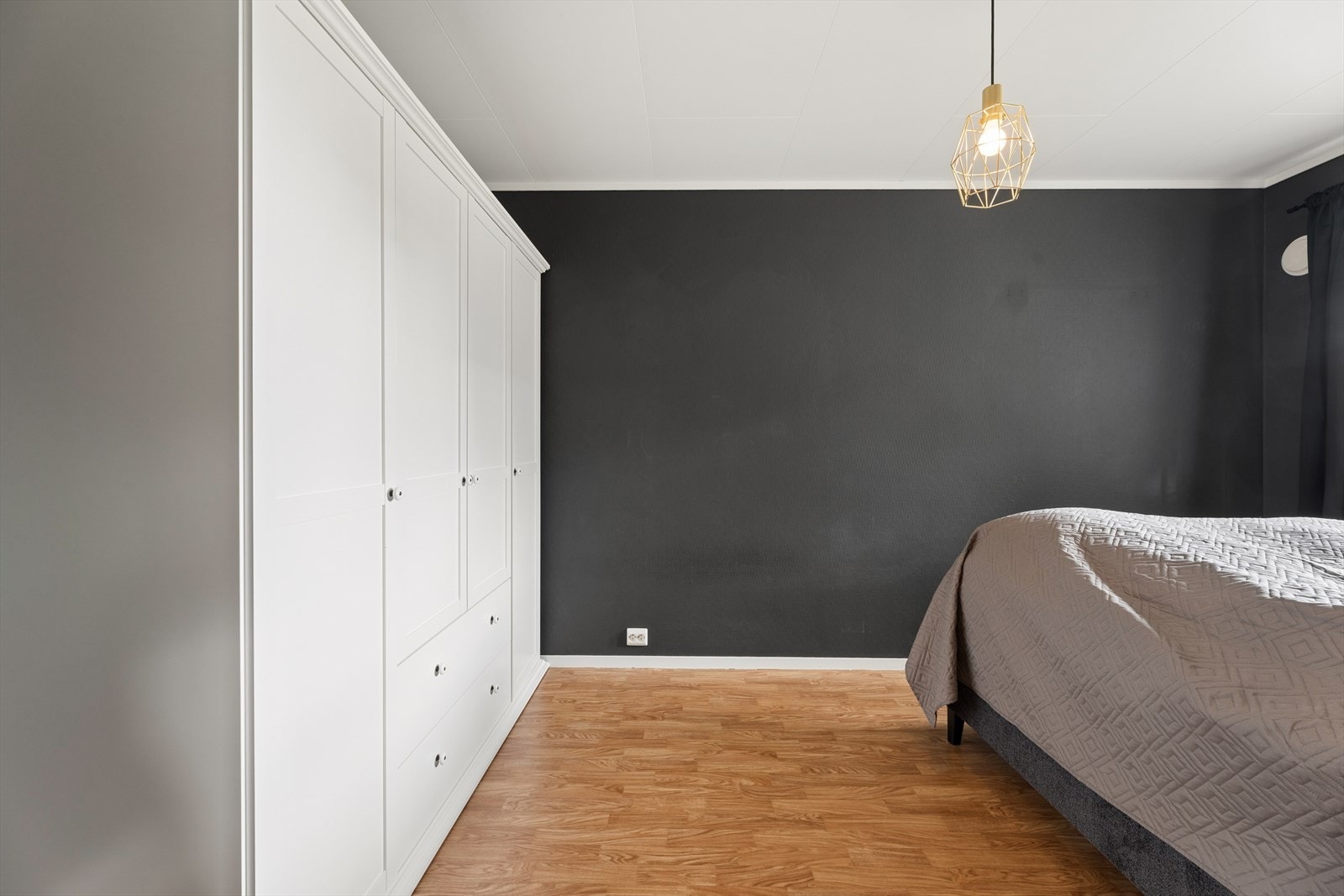 Det er god plass til en romslig garderobeløsning langs den ene veggen, som gir praktiske og oversiktlige oppbevaringsmuligheter. Galleribilde