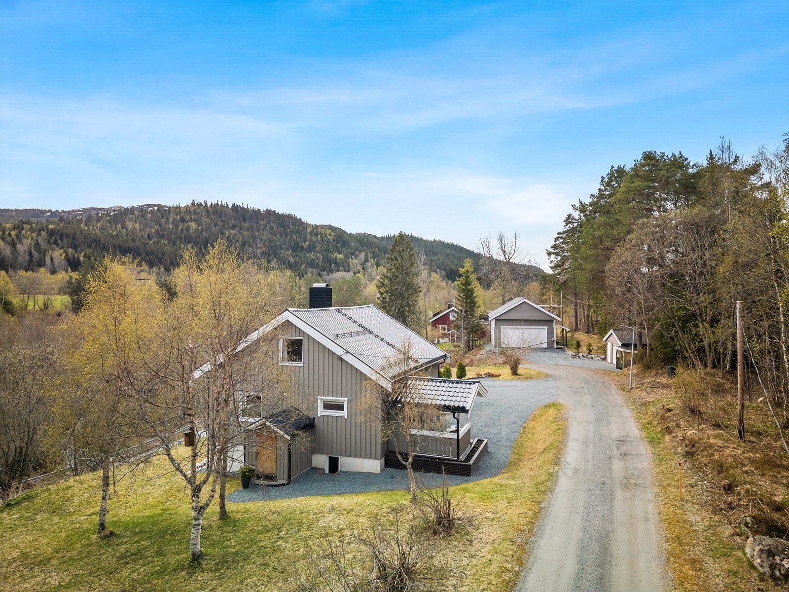Dronefoto: Her ser man enebolig og garasje. Stor eiertomt med både stort grøntareal og biloppstillingerplasser. Galleribilde
