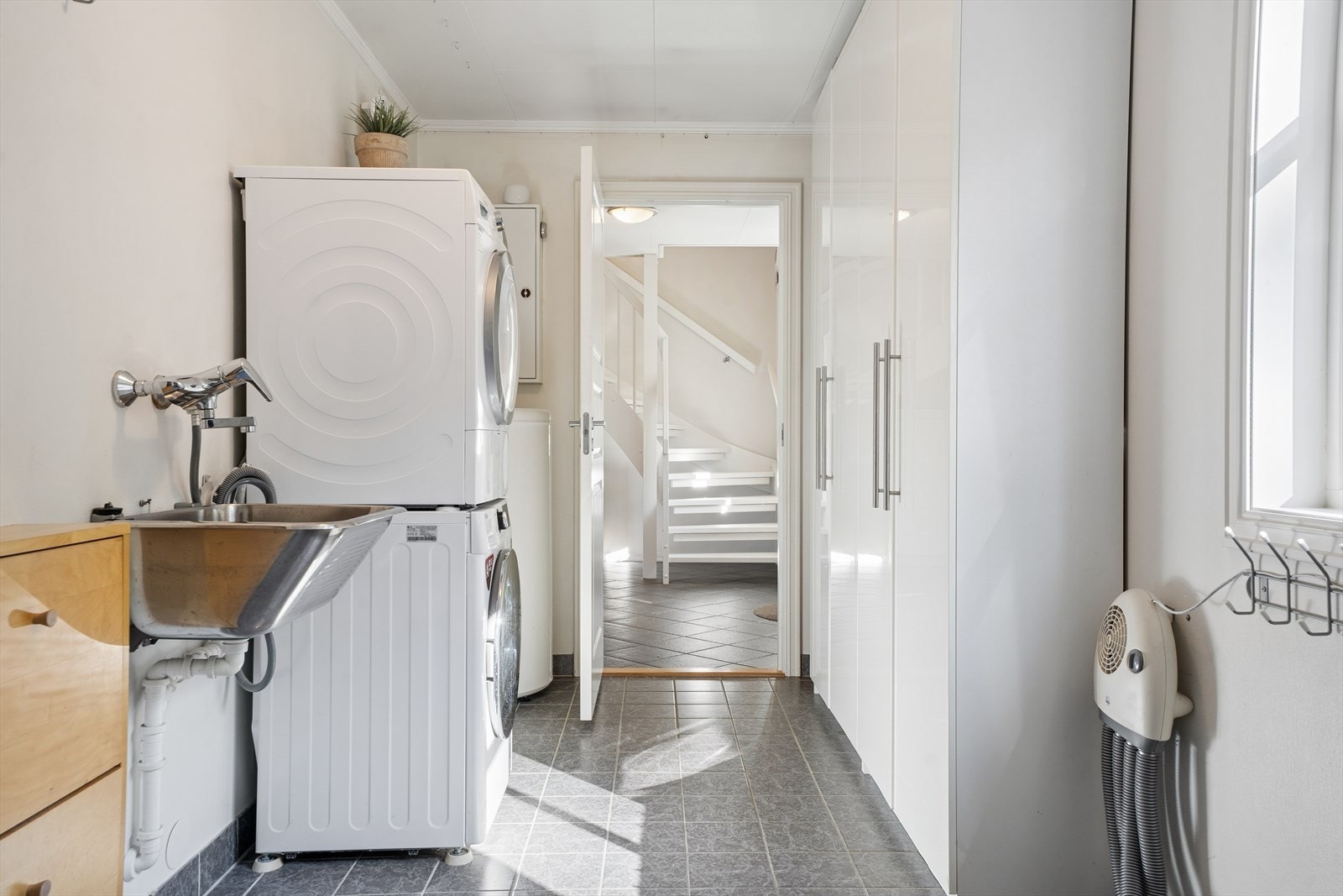 Rommet har flislagt gulv med varme, opplegg for vaskemaskin og skyllekar. Galleribilde