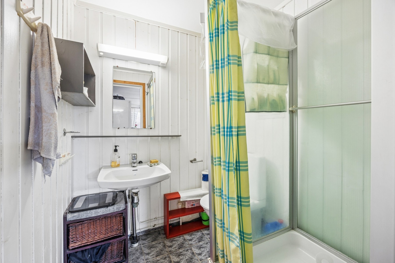 Badet i utleiedelen har trepanel på veggene, flislagt gulv og dusjkabinett. Galleribilde