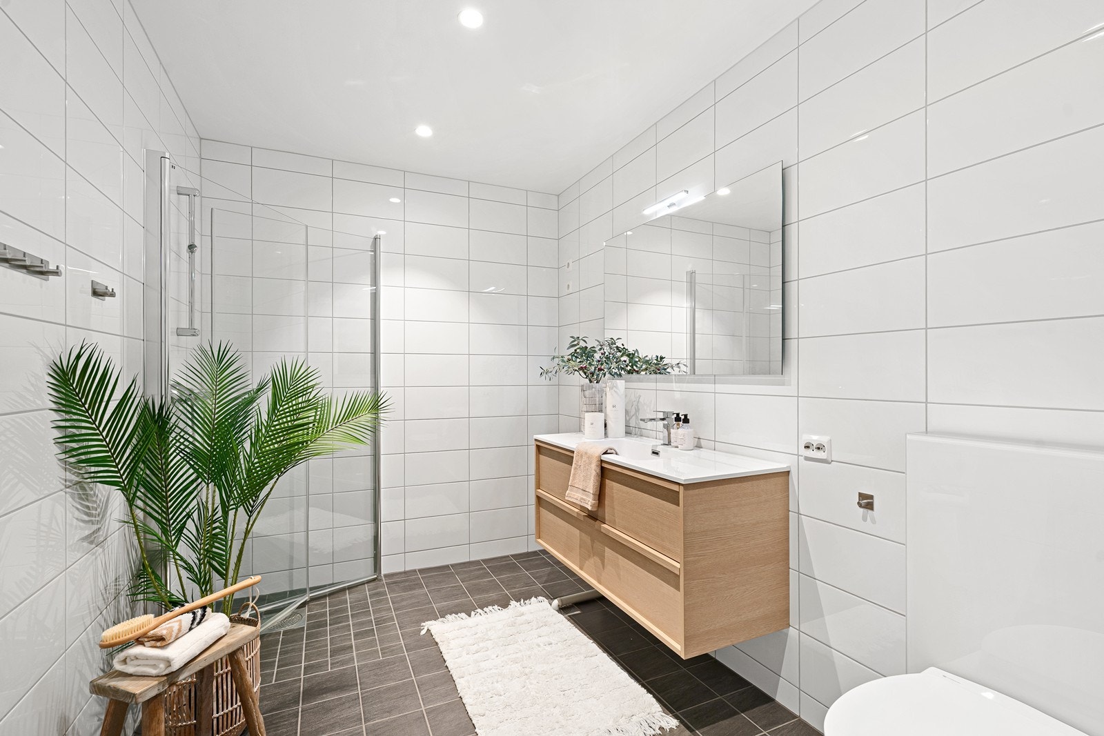 Lekkert helfliset bad med gulvvarme, som fremstår moderne og innbydende. Badet er innredet med nedfelt servant, veggmontert toalett, dusjhjørne med glassvegger - en funksjonell og gjennomtenkt planløsning. Galleribilde
