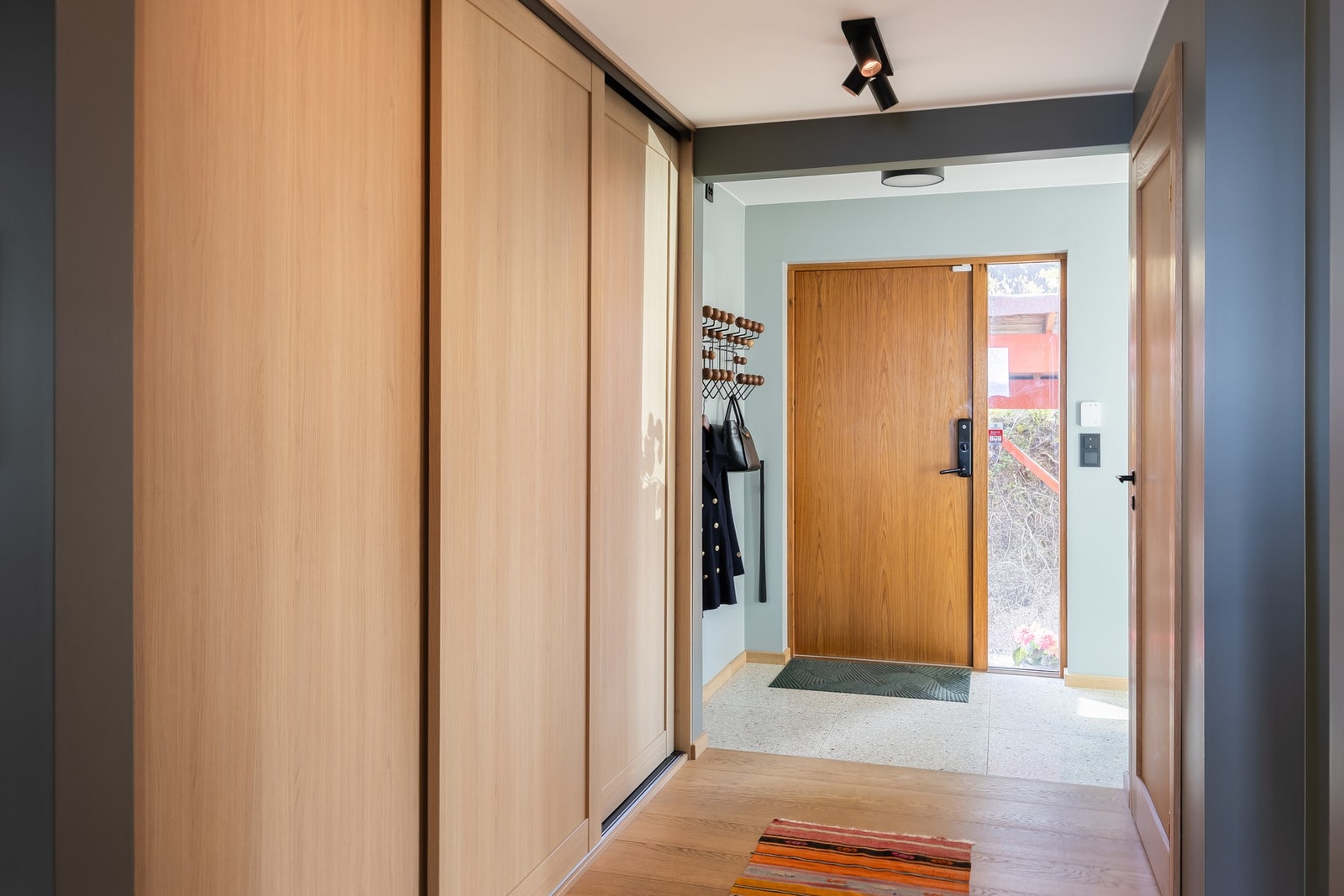 Man kommer inn i en flislagt entré på 6,2m² utstyrt med skyvedørsgarderobe. Deretter til en romslig hall på 17m², også her finner man en skyvedørsgarderobe. Galleribilde