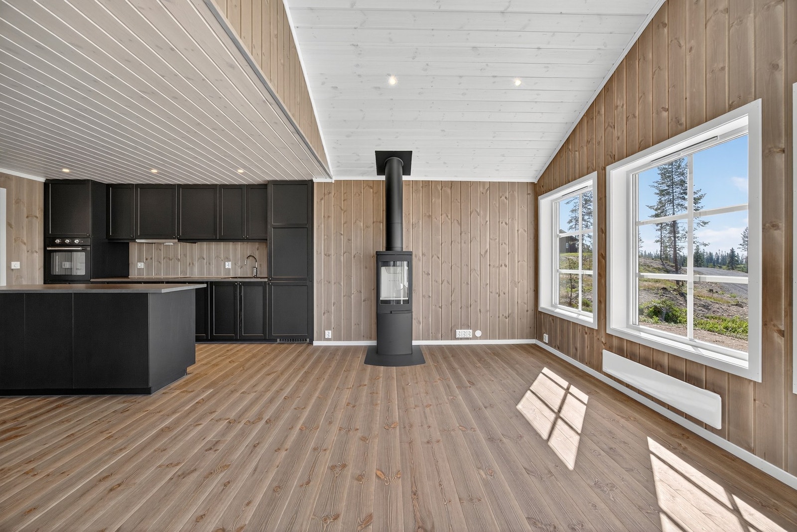 De store vinduene gir en pent naturlig lys inn i rommet. Bildet er ikke av selve hytta. Galleribilde