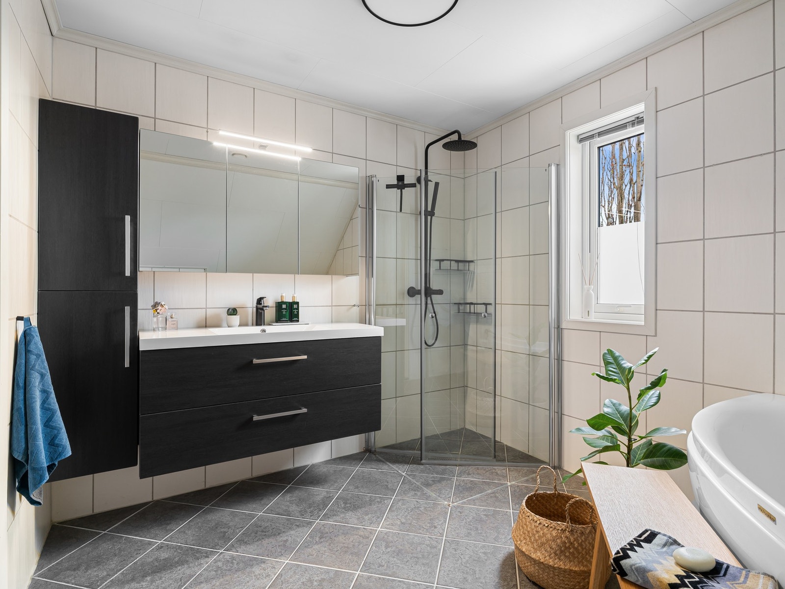 Badet på loftet har fliser på både gulv og vegger. Badet er innredet med baderomsinnredning med nedfelt servant, vegghengt skap og speil. Galleribilde