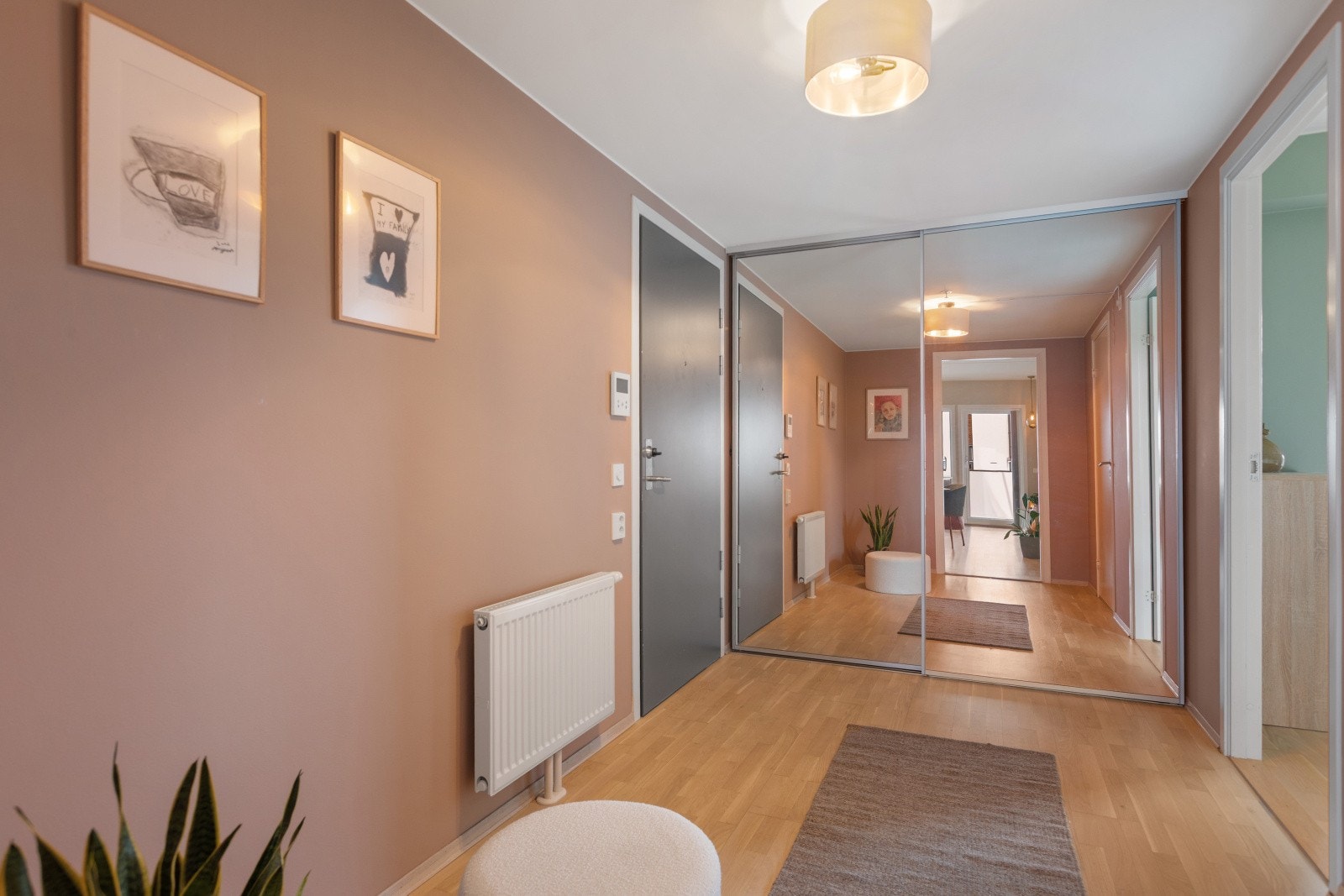 Du ønskes velkommen inn i en lys, romslig og meget innbydende entré som gir et svært godt førsteinntrykk av boligen. Her finner du en praktisk skyvedørsgarderobe med speilfronter som både gir et stilrent uttrykk og god oppbevaringsplass. Galleribilde