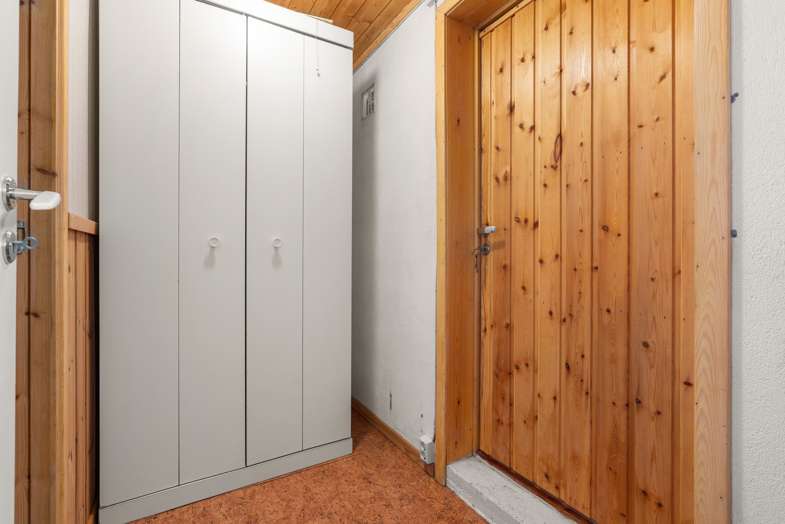 Gang med garderobeskap og trepanel på vegger og tak. Galleribilde