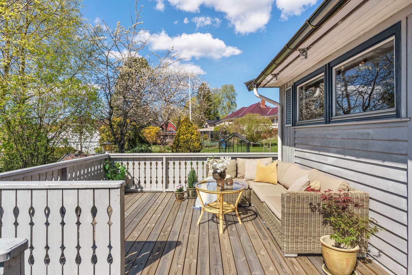 Lys og romslig terrasse med utsikt mot hage og nabolag. Galleribilde