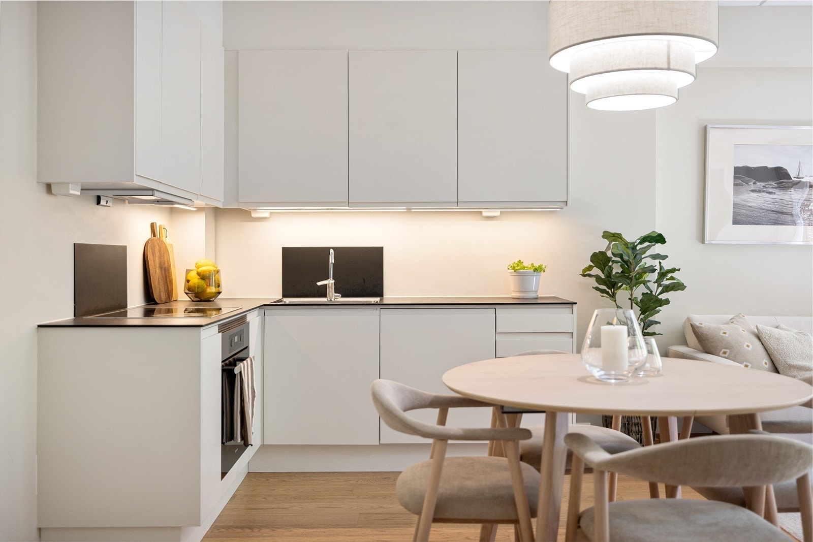 Moderne kjøkkeninnredning fra kvalitetsleverandøren Sigdal med glatte fronter og kompakt laminat benkeplate med platetopp og nedfelt oppvaskkum. Galleribilde