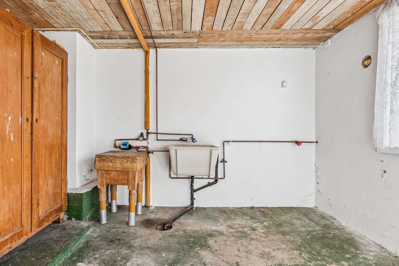 I vaskekjelleren er også stoppekran og vannmåler plassert. Overflatene består av malt mur og betong. Galleribilde