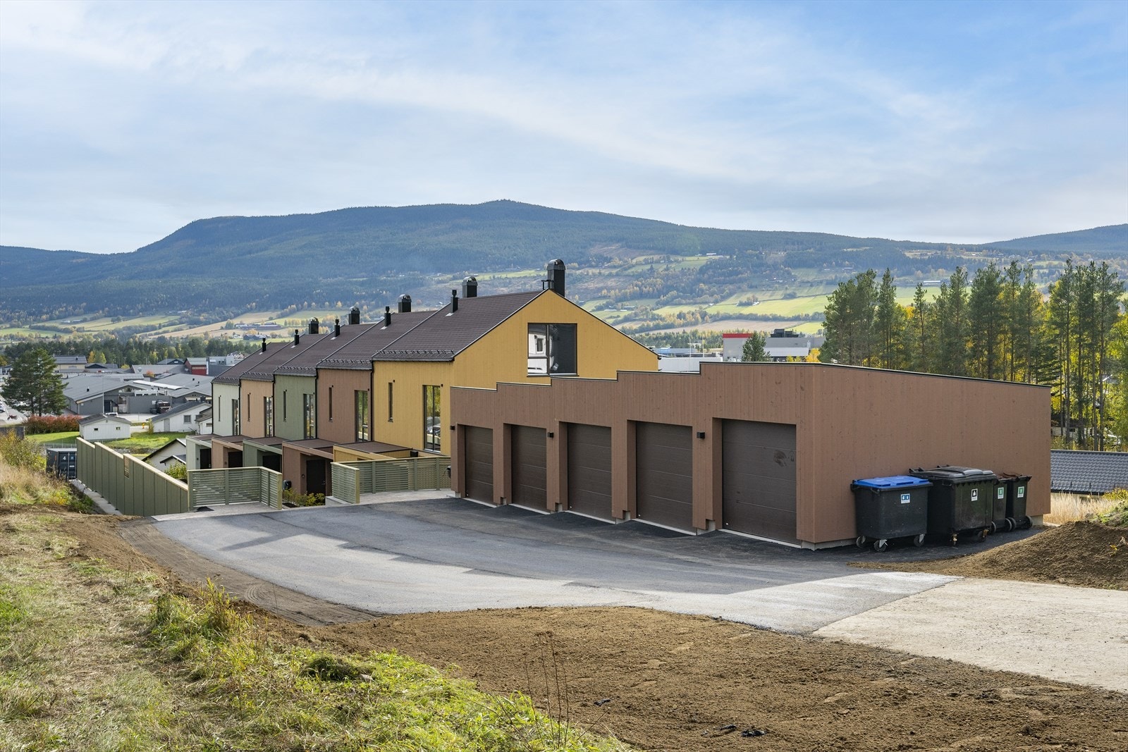 Hvert rekkehus har egen garasje med el-port, og det er tilrettelagt for el-billader. I tillegg asfaltert gårdsplass med gjesteparkering. Galleribilde