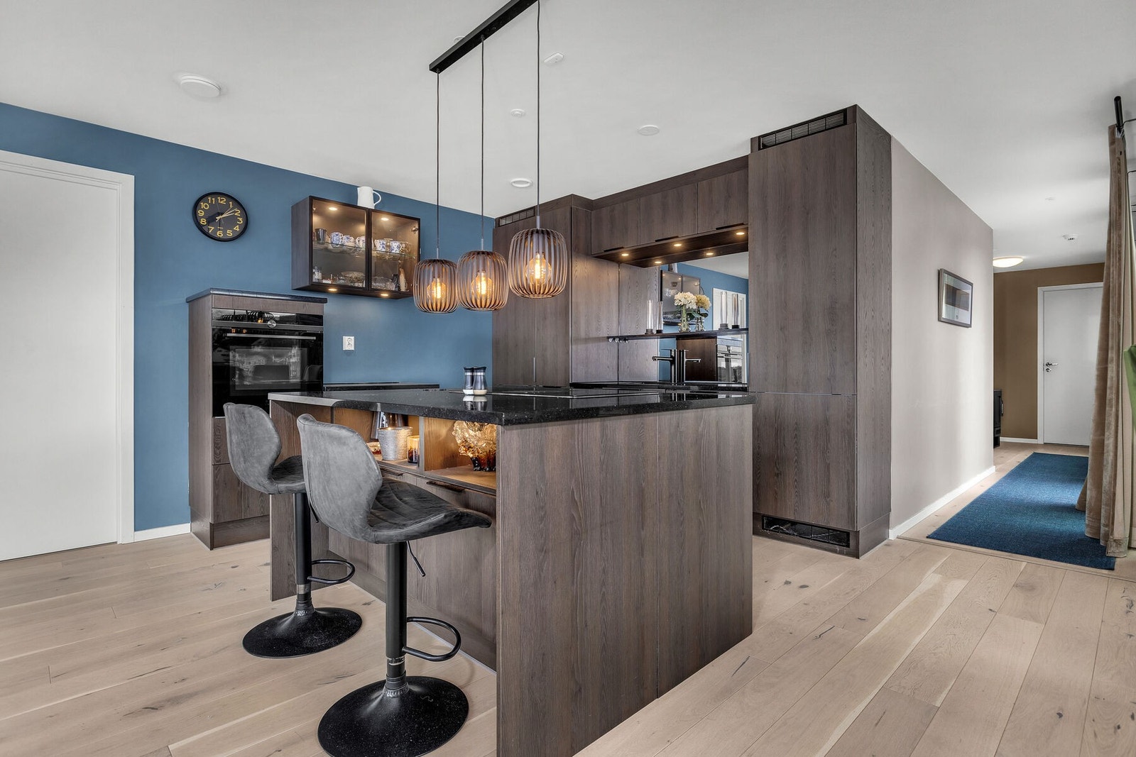 Moderne kjøkkeninnredning med mørke fronter og rikelig med skap- og benkeplass. Galleribilde