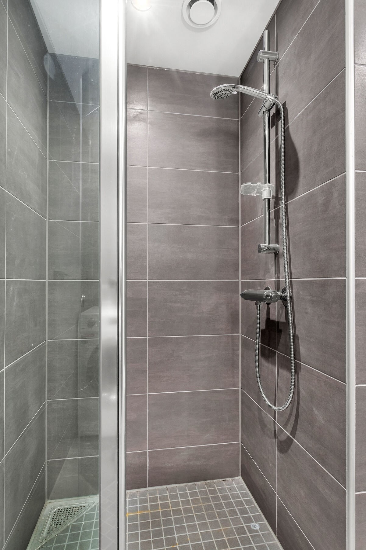 Også dette badet har et dusjhjørne med innfellbare glassdører. Galleribilde