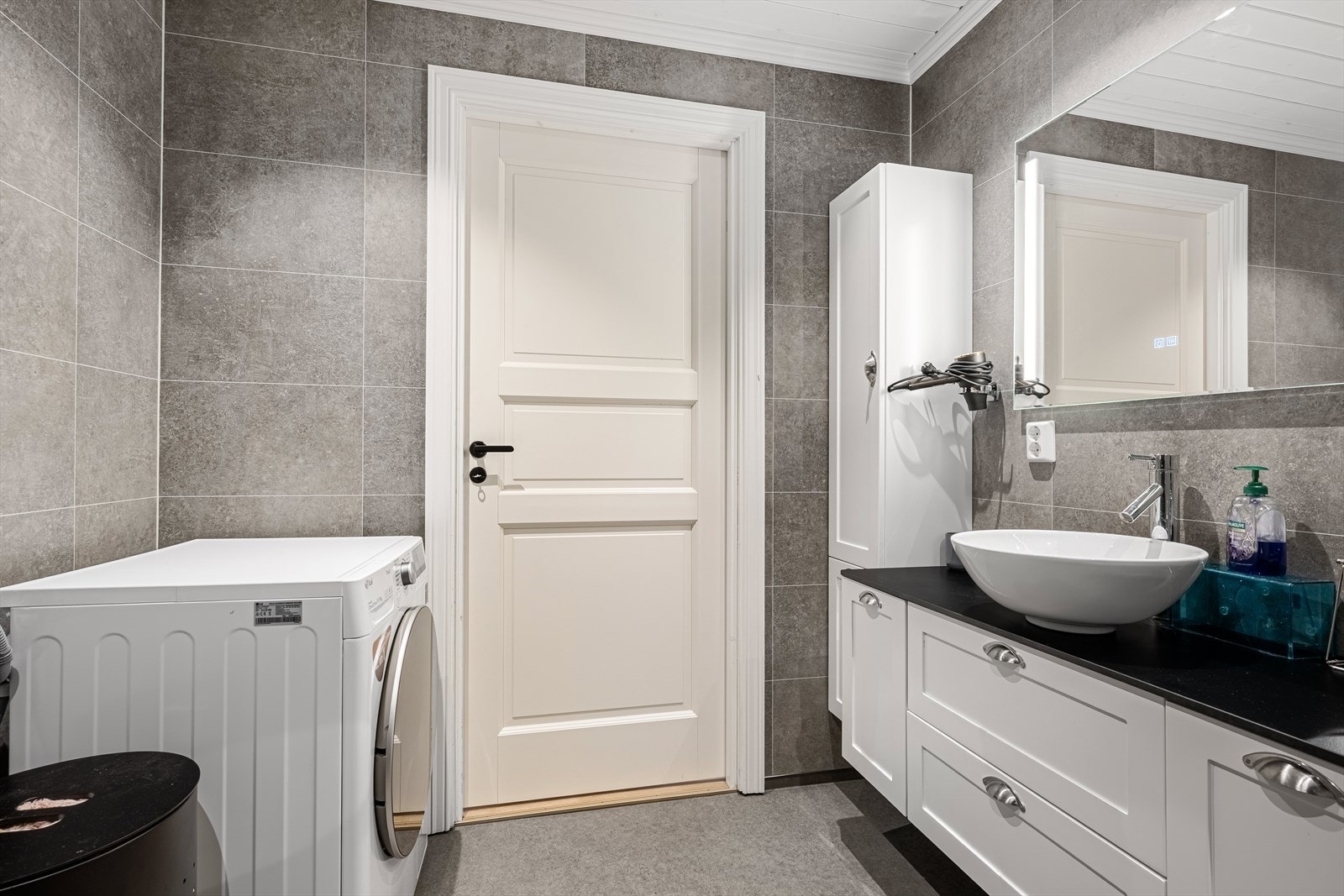 Badet inneholder servant med side- og underskap, speil, wc, innfellbare dusjvegger og opplegg til vaskemaskin. Galleribilde