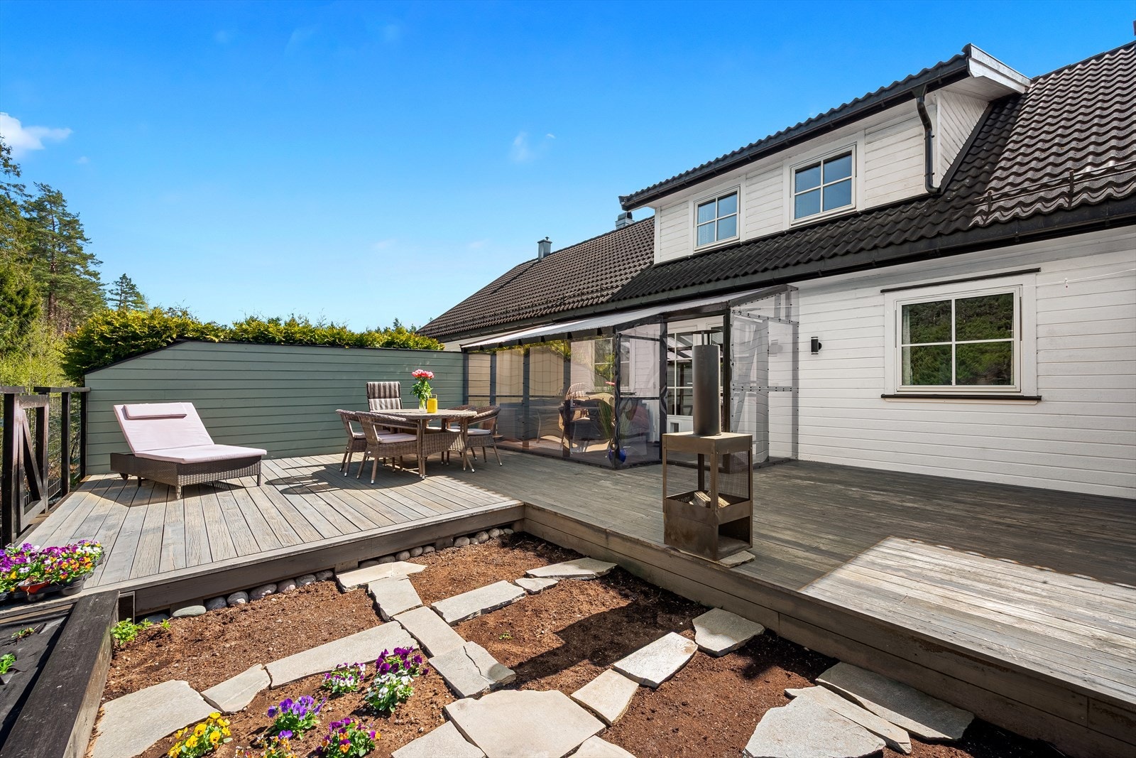 Enheten disponerer en stor, nordvendt terrasse med utgang fra stue/kjøkken. Her er det bygget en enkel vinterstue/innbygd terrasse, samt en stor terrasse, en koselig liten hage og gjerder og levegger. Galleribilde