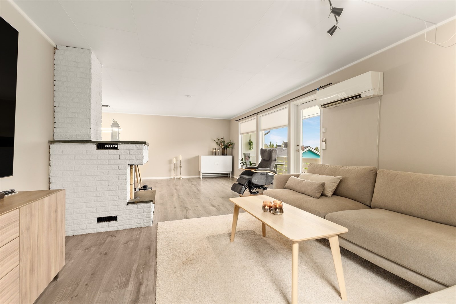 Stue er lys og moderne, malt i behagelige fargetoner. Her er store vindusflater som slipper inn rikelig med dagslys, og utgang til veranda med utsikt i retning nedre deler av Grubhei og ellers nærliggende områder. Galleribilde