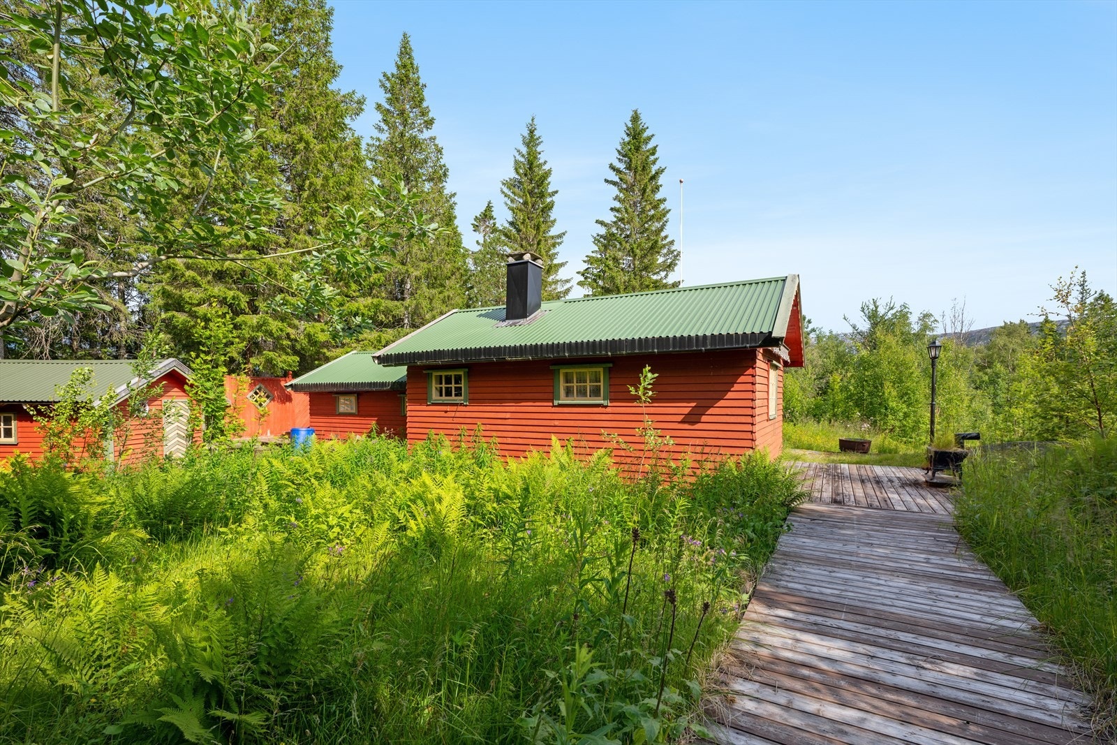 Eiendommen ligger tilbaketrukket, omgitt av skog. Parkering på egen tomt. Galleribilde