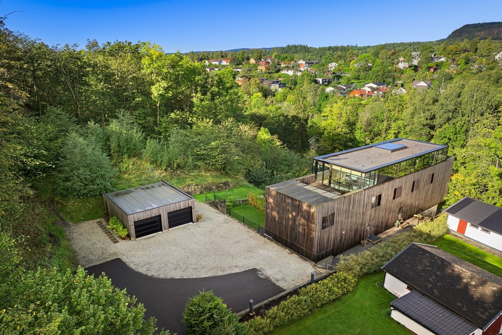 Én garasjeplass og ellers plass til flere biler på tunet til tomannsboligen Galleribilde