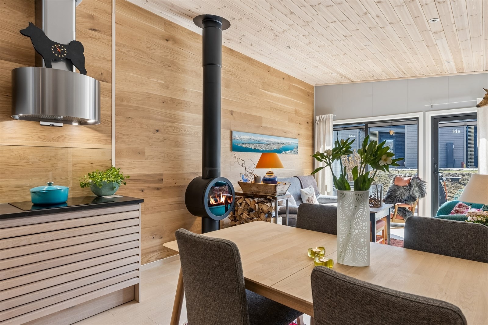 Spiseplassen er et naturlig samlingspunkt mellom kjøkkenet og stuen. Det er satt inn pipe og kul peisovn her inne, noe som ikke mange av de andre husene har. Det er kun en annen enhet i sameiet som har etablert ildsted. Galleribilde