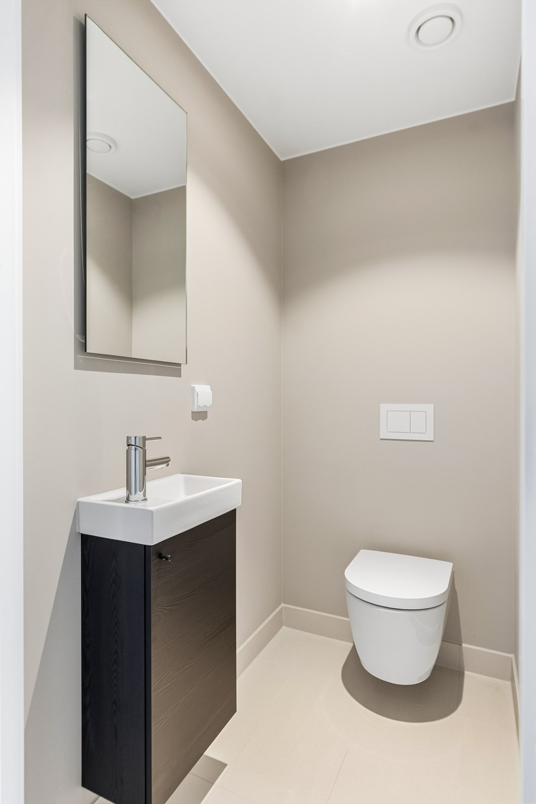 Vegg i vegg med badet er det etablert et smart gjestetoalett. Rommet har veggmontert vannklosett, samt servant. Galleribilde