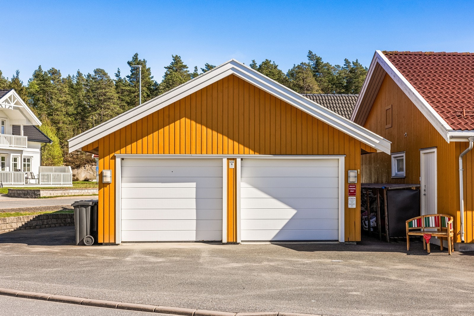 Garasjen har to leddporter med elektriske løftere, samt en sidedør for enkel tilgang. Galleribilde