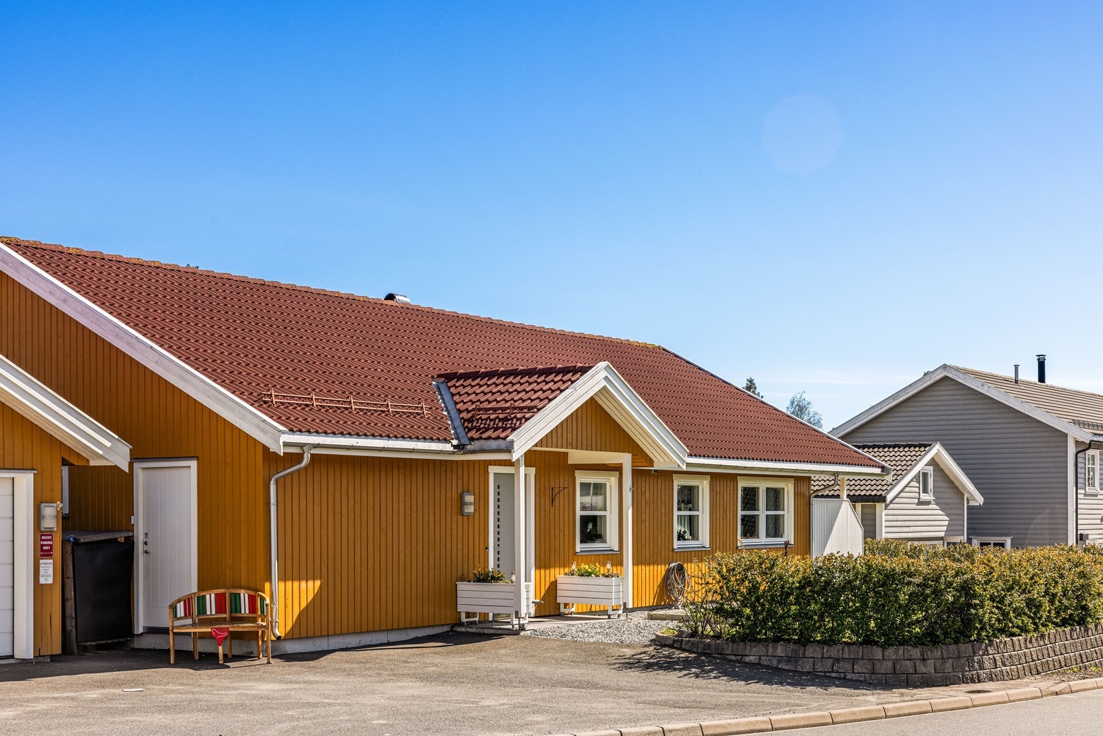 Boligen har fasade med stående bordkledning og betongtakstein. Galleribilde