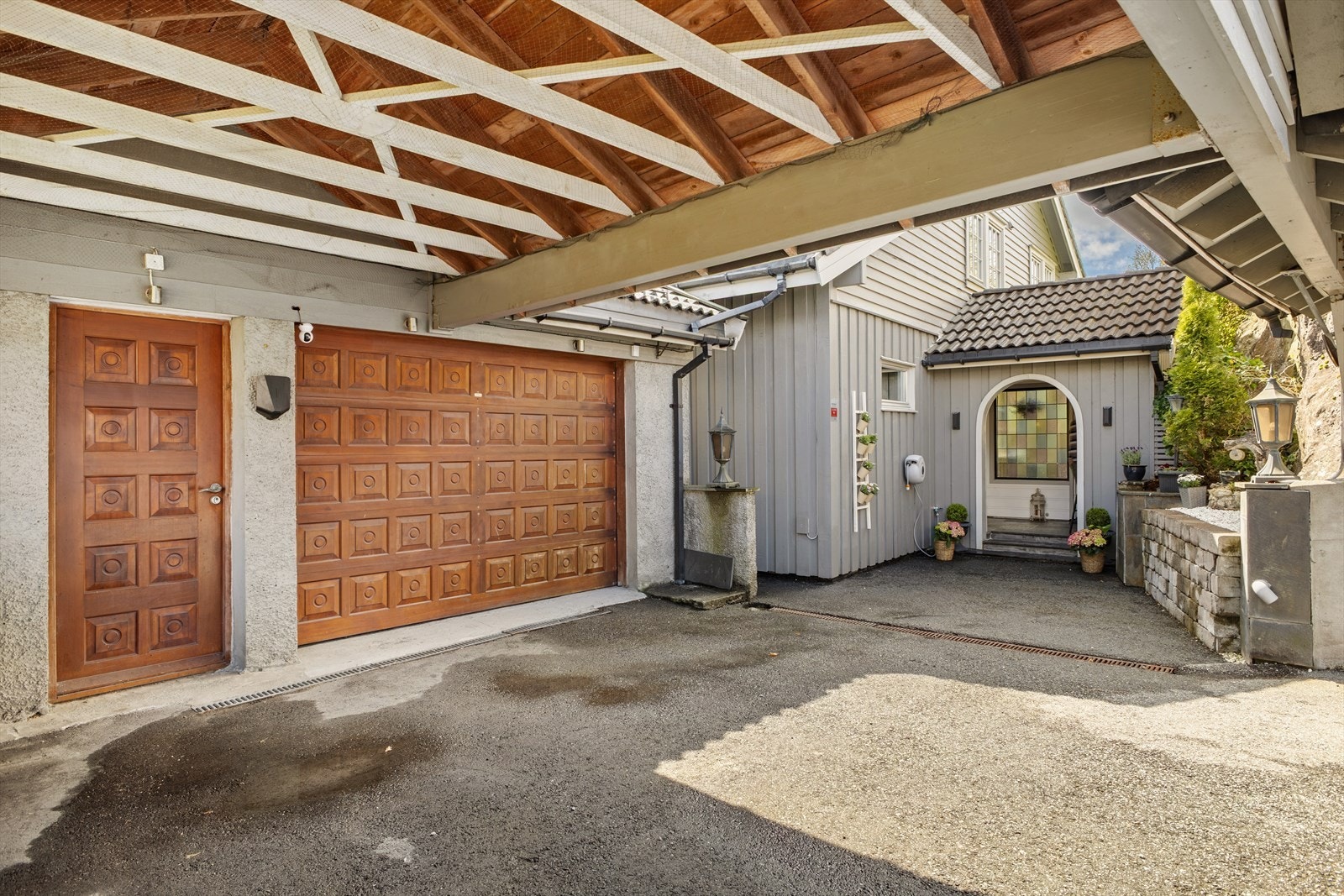 Eiendommen har gode parkeringsmuligheter med både garasje, carport og tre ekstra biloppstillingsplasser. Det er installert elbillader ved garasjen. Galleribilde