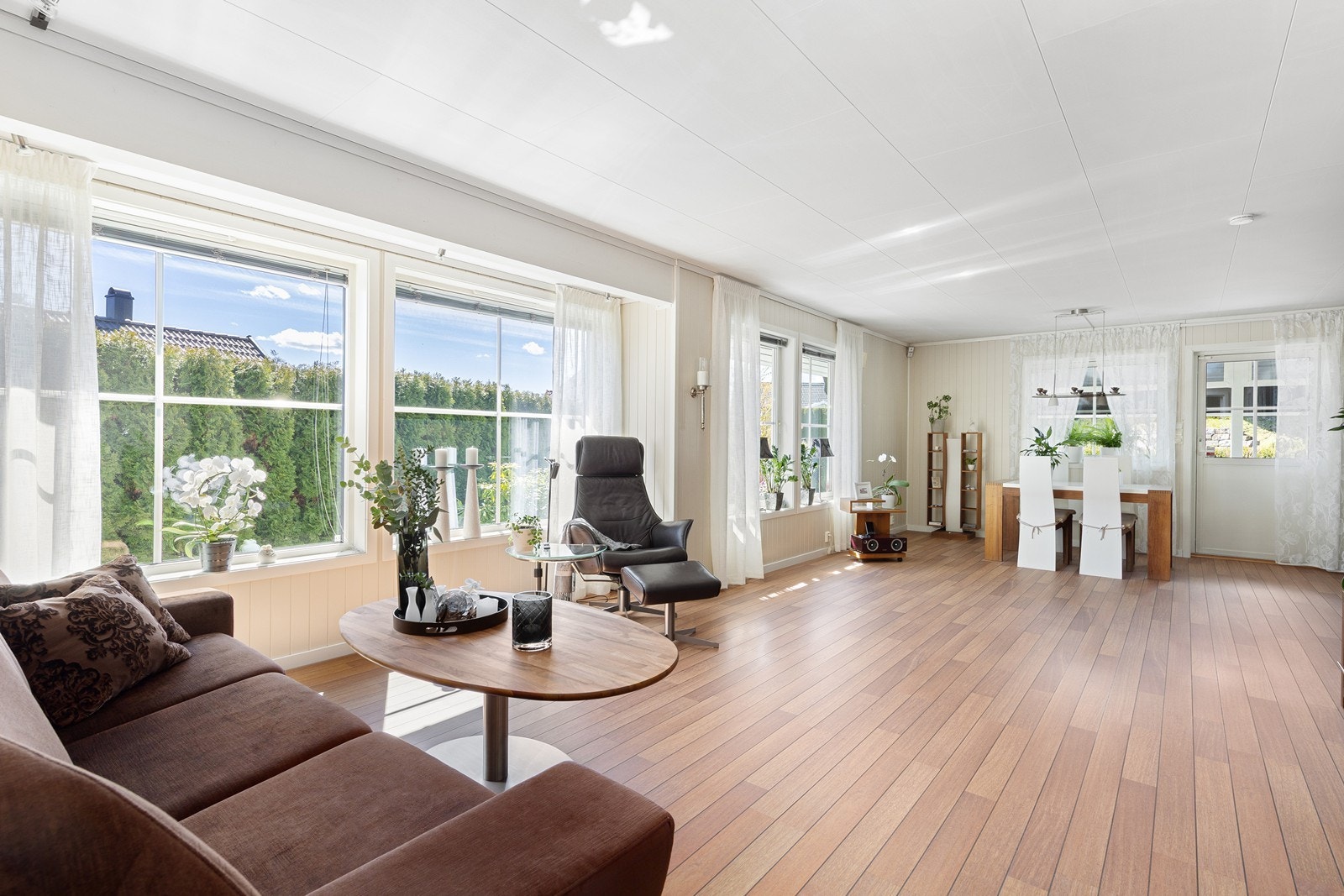 Den åpne løsningen mellom stue og kjøkken gir en romslig og sosial sone, med gjennomgående laminatgulv. Galleribilde