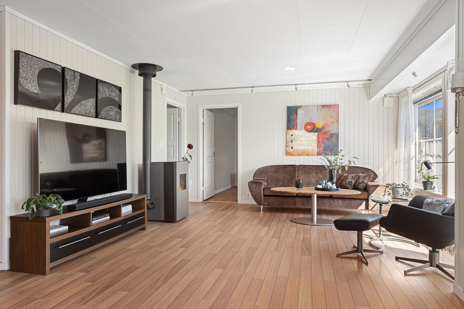 Stuen har god plass til flere sittegrupper og er kledd med malte Mdf-panelplater på veggene. Galleribilde