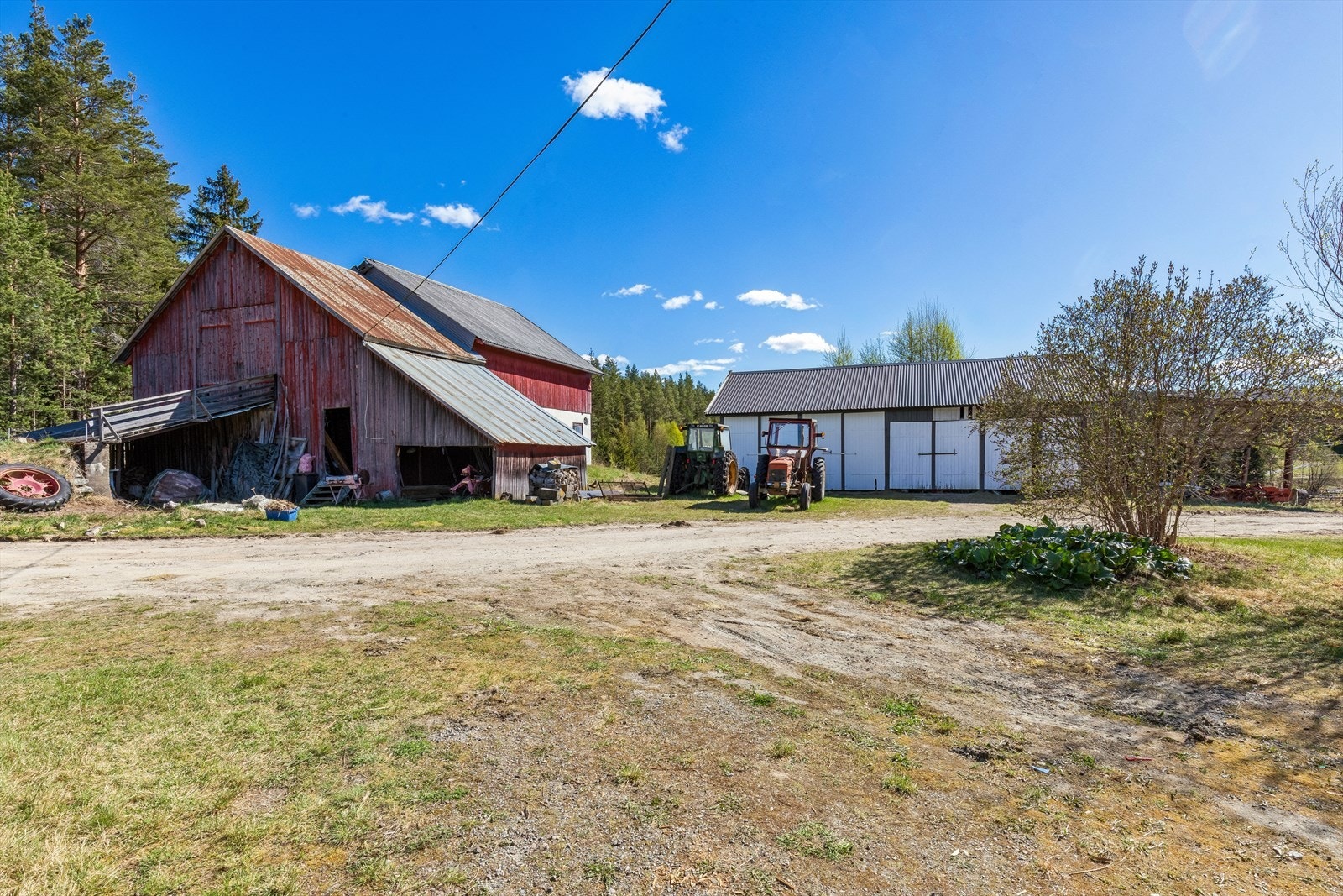 Eiendommen inkluderer en romslig låve på 254 m², et uthus med to garasjer og en separat dobbelgarasje. Galleribilde