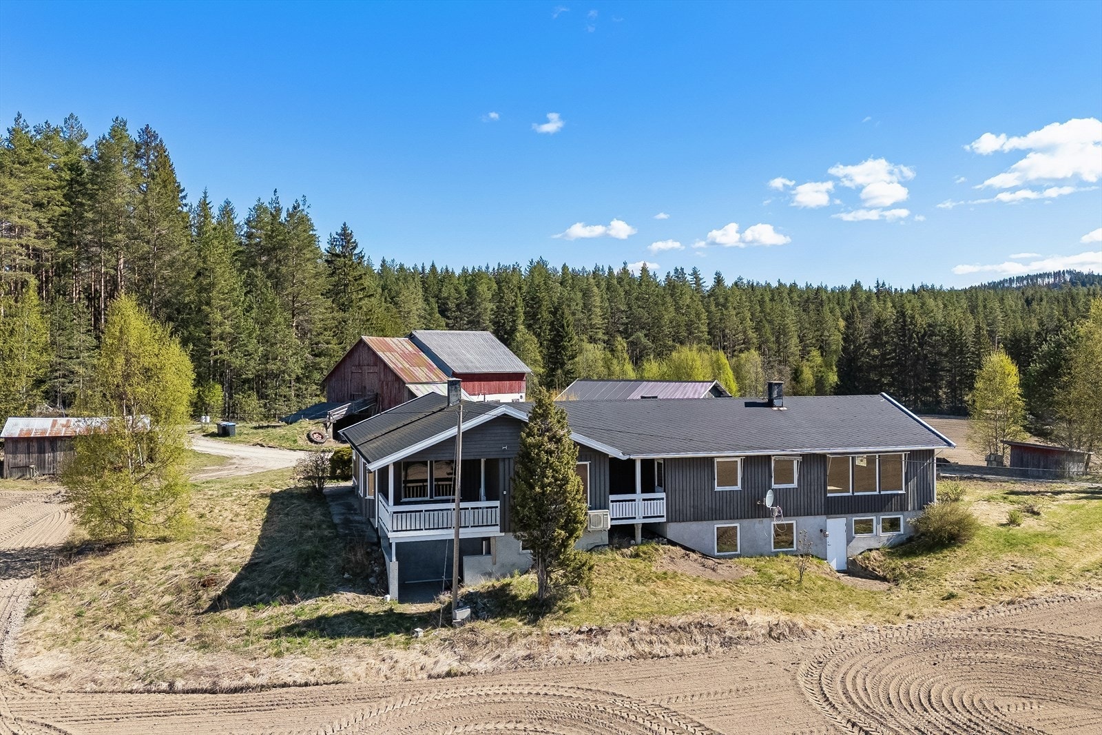 En innholdsrik generasjonsbolig med to boenheter, stor låve og flere garasje. Galleribilde