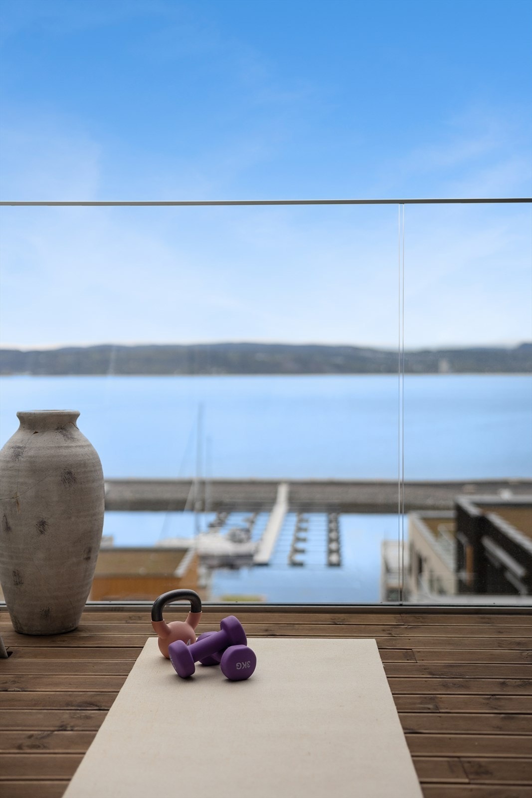 Rekkverk i glass sikrer en uforstyrret utsikt mot fjorden og båthavnen. Galleribilde