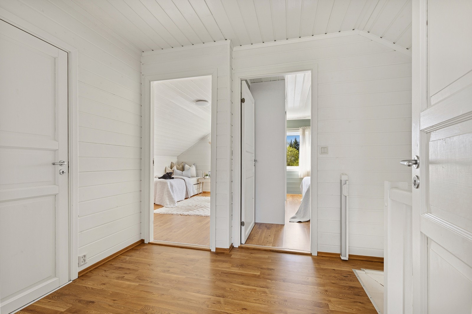 Gjennomgående bruk av trepanel i himling og på vegger gir en helhetlig stil i loftsetasjen. Galleribilde