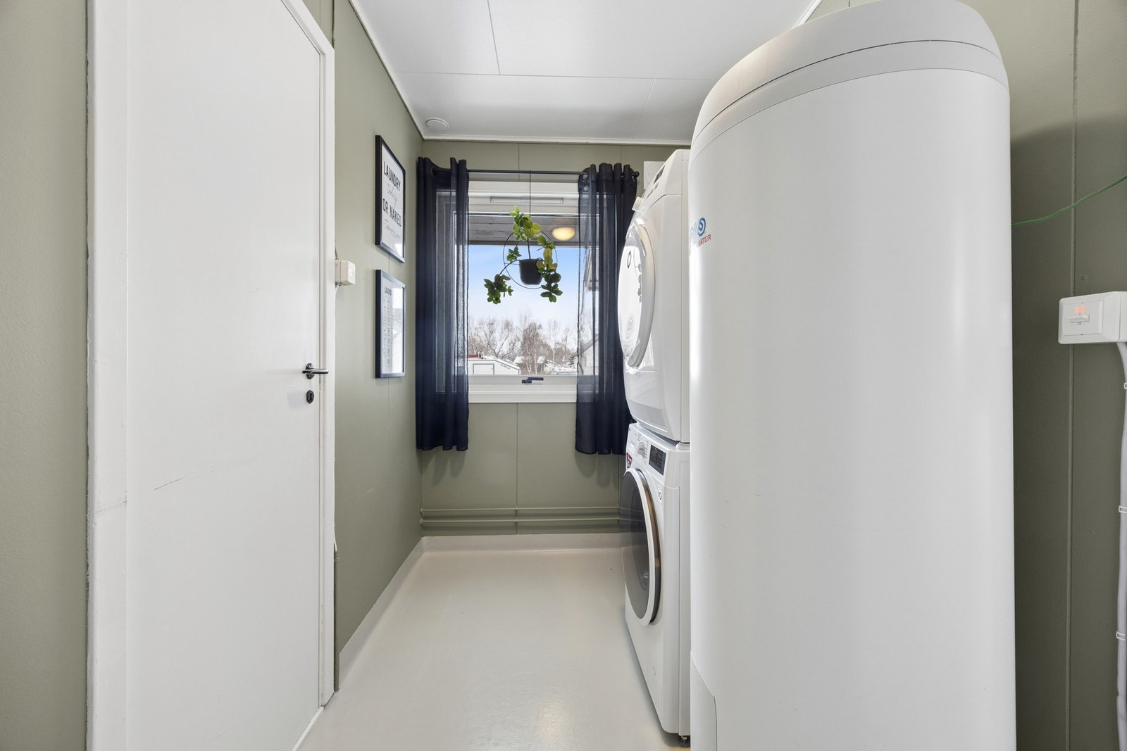 Separat vaskerom med opplegg for vaskemaskin og en 300-liters varmtvannsbereder fra 2019. Galleribilde