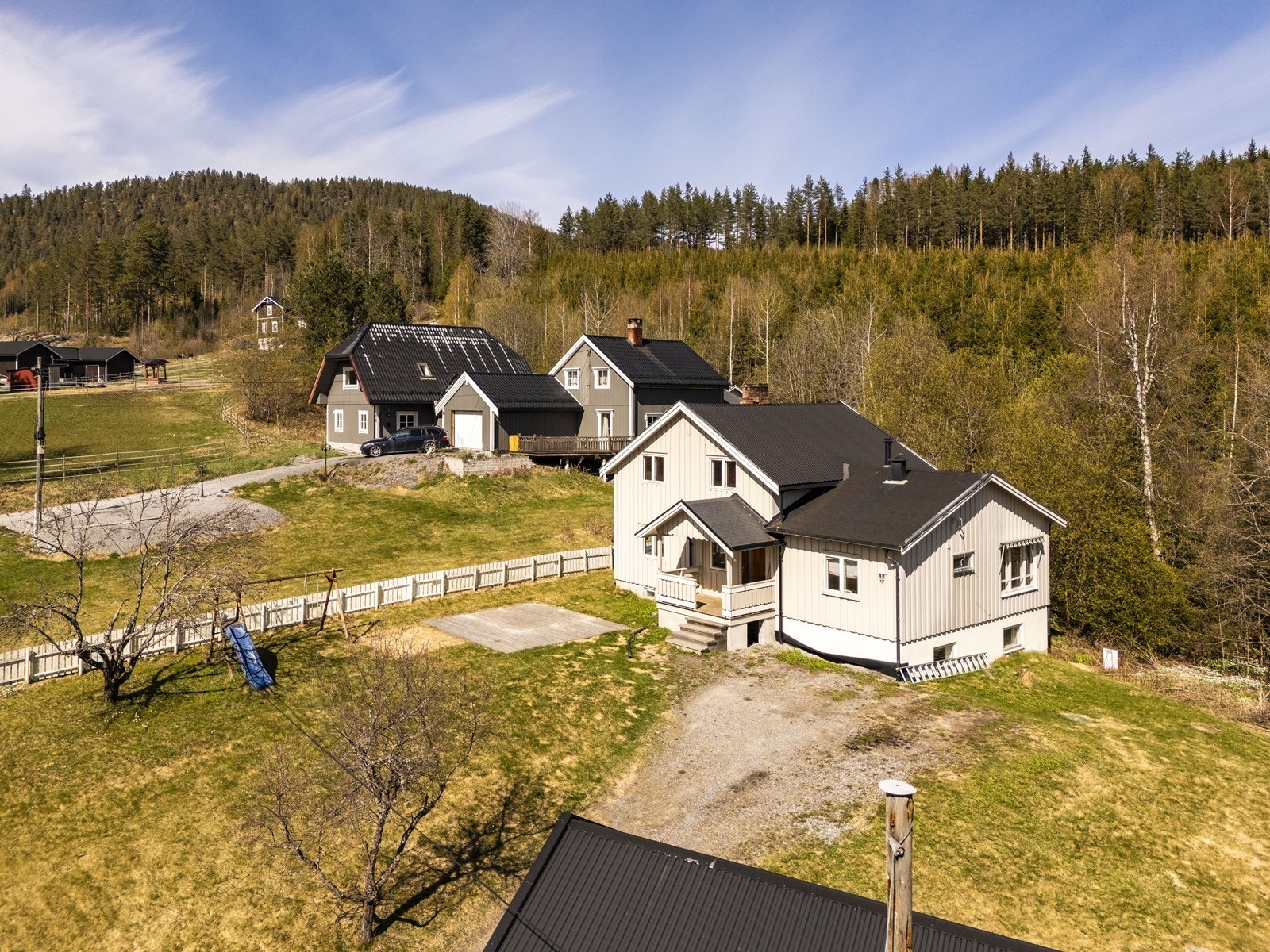 Tomten er opparbeidet med plen og gruset gårdsplass. Galleribilde