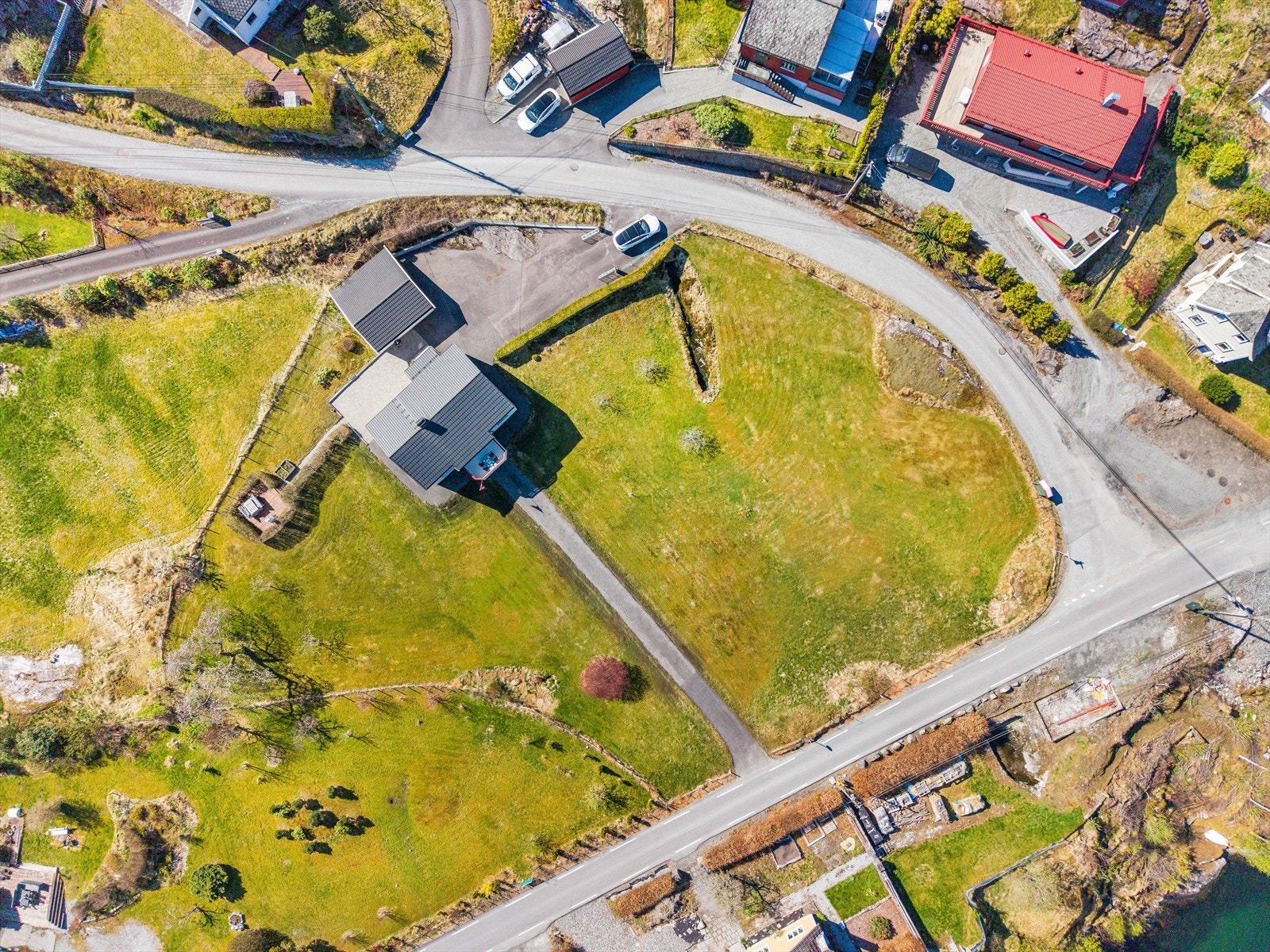 Tomten er pent opparbeidet med plen og asfaltert gårdsplass. Galleribilde